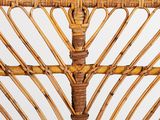 a close up of a wicker chair with a white wall in the background
