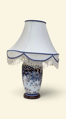 une lampe de table bleue et blanche, surmontée d'un abat-jour blanc