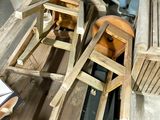 a pile of wooden chairs and a table in a room