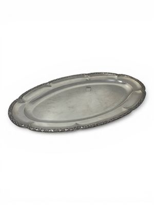 an oval silver tray with a beaded edge on a white background