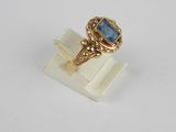 an image of a gold ring with a blue stone in it