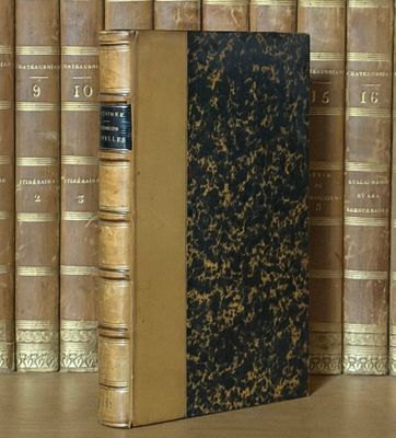 un livre posé sur une table, devant une pile de livres