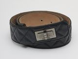 ceinture en cuir matelassé noir avec une boucle métallique sur fond blanc