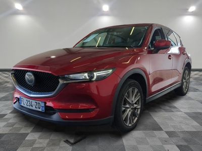 a red mazda cx - 5 parked on a checkered floor