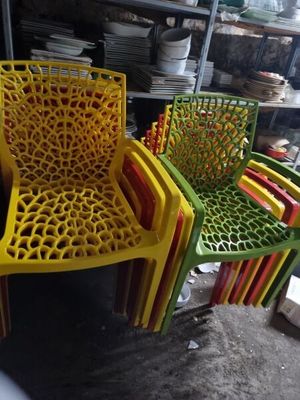 four plastic chairs sitting next to each other in a room