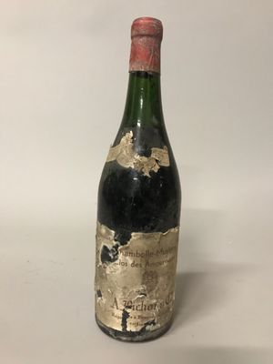 une vieille bouteille de vin posée sur une table blanche