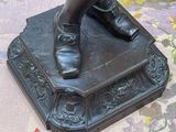 a bronze statue of a person standing on top of a book