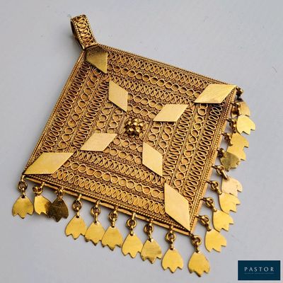 une photo d'un pendentif plaqué or orné d'éléphants