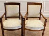 deux chaises en bois posées sur un parquet, près d'un mur blanc