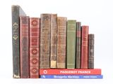 plusieurs vieux livres sont empilés sur une surface blanche