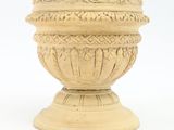 a vase that has a bird on it on a pedestal