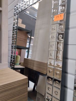 une grande pile de cartons dans un magasin, avec un miroir accroché au mur