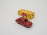 a red toy car next to a yellow box on a white surface