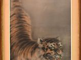 tableau représentant un tigre bondissant au-dessus d'un plan d'eau, dans un cadre en bois
