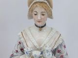 a figurine of a woman holding a tea cup and saucer