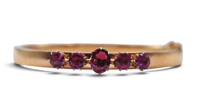 un gros plan d'une bague en or sertie de trois pierres violettes