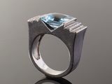 a close up of a ring with a blue topaz stone