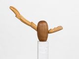 wooden sculpture of a bird on a white pedestal with a white background