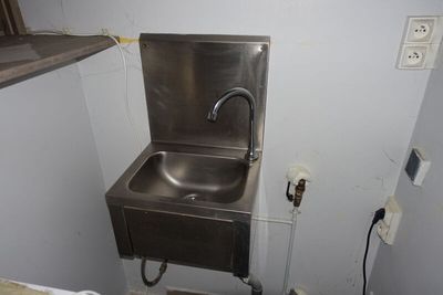 un évier en acier inoxydable dans le coin d'une salle de bains