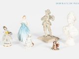 cinq figurines de styles et de tailles variés posées sur un fond blanc