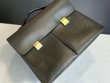 a black leather handbag sitting on top of a white table