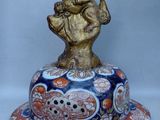 une figurine représentant un homme tenant un oiseau, posée sur une assiette