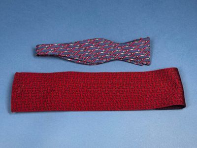 two pieces of red fabric with a bow tie on a blue surface