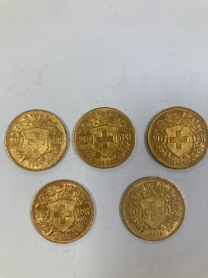 quatre pièces d'or présentant des motifs différents, posées sur un fond blanc