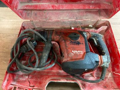 a red tool box with tools in it on a wooden floor