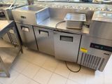 une grande cuisine avec de nombreux plans de travail en inox