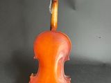an old violin sits on a stand against a gray background