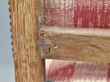 a close up of a wooden chair with a red and white blanket