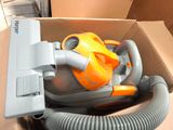 une boîte contenant un aspirateur et un tuyau