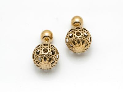 une paire de boucles d'oreilles dorées ornées de motifs en filigrane
