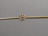 a single diamond is being held by a tweet of wire