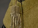 a green hat with a tassel on top of it