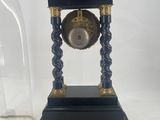 a black clock under a glass dome on a table