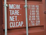 une inscription sur le flanc d'un conteneur d'expédition indiquant « mgw tare net culap »