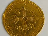 a close up of a gold coin with a cross on it