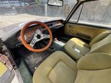a dashboard and steering wheel of a car in a parking lot