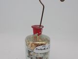 une bouteille en verre munie d'un crochet et portant une étiquette