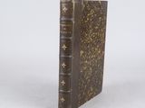an old book sitting on top of a white surface
