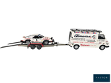 a truck pulling a car on a trailer with a trailer attached to it