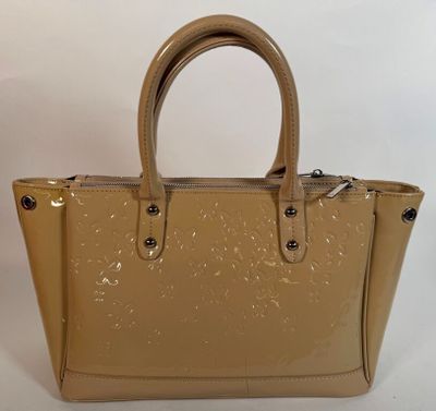 un sac à main beige muni d'une poignée en métal et d'une fermeture à glissière