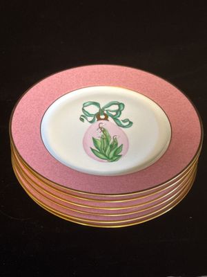 une pile d'assiettes ornées d'un motif rose et blanc
