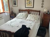 un lit recouvert d'un couvre-lit blanc et une valise noire