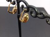 a pair of earrings on a stand on a table