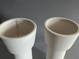 two white vases sitting next to each other on a table