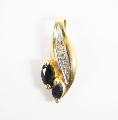 a close up of a gold and black diamond pendant on a white background