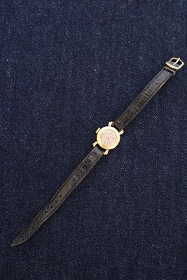 a watch sitting on top of a blue surface next to a pair of scissors